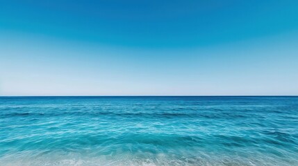 Obraz premium A clear blue sky reflecting on the tranquil sea, with a lone surfer waiting for a wave, summer sea, relaxation, surfing vibes