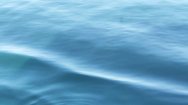 Blue sea water surface waves ripples and ship wake texture 4k footage