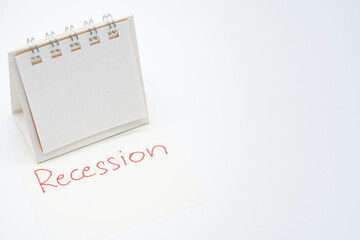 Hand writing Recession on paper note with blank calendar and copy space.