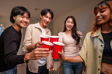 Group of Asian friends having evening party in living room at home. 