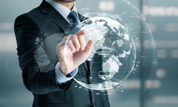 Global Connectivity: A businessman interacts with a transparent digital globe, symbolizing global reach, connectivity, and technological advancement.  