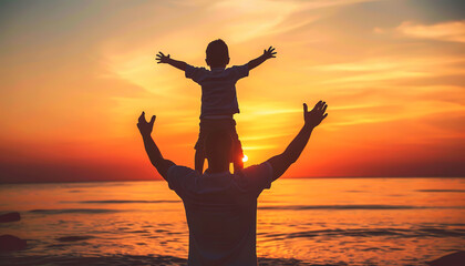 Fototapeta premium Silhouette of a father and son at sunset with arms raised on the beach