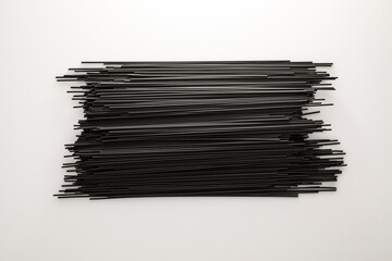 Raw black spaghetti made with cuttlefish ink on white.