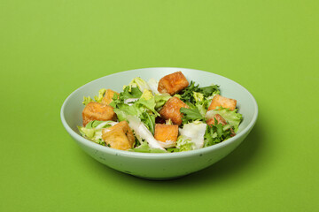 Fried tofu salad on a green background