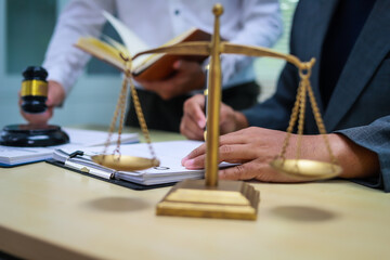 Obraz premium A lawyer is seated at a desk in an office, reviewing and signing legal documents. The scene captures a professional setting focused on contracts, finance, providing legal advice to clients.