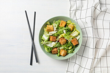 Fried tofu salad in a bowl with chopsticks
