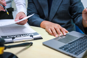 A lawyer is seated at a desk in an office, reviewing and signing legal documents. The scene captures a professional setting focused on contracts, finance,  providing legal advice to clients.