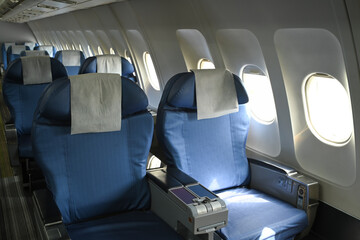 Row of empty airplane seats with natural sunlight streaming through the windows