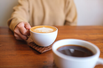 Closeup image of a couple people holding and drinking coffee together