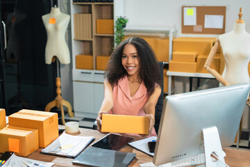 Happy woman smiling at sales success after checking profits from home online store, concept of...