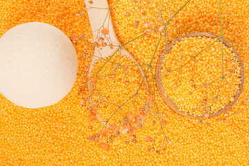 Composition of orange pearls and bath bombs, top view