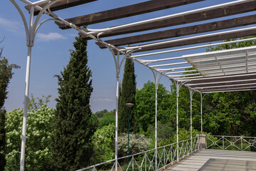 A white gazebo with a wooden roof and a view of trees