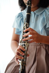 Fototapeta premium 吹奏楽部でクラリネットパートを担当している小学5年生の女の子。自宅で自主練。