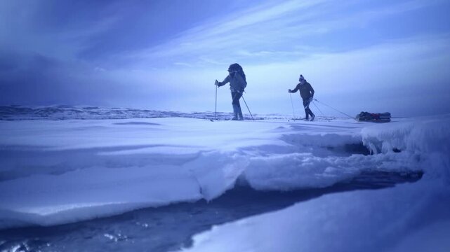 Lockdown Shot Of Men Walking With Skis And Ski Poles On Snowy Landscape In Tranquil National Park Under Cloudy Sky - Denali National Park, Alaska