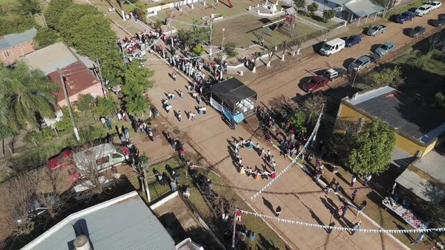 A done panning shot over people at the Argentine flag ceremony dancing chacarera.