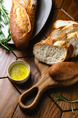 French baguette with olive oil and fresh rosemary on a kitchen table