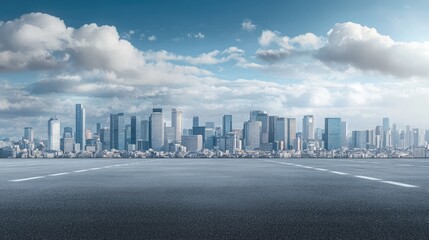 Empty asphalt road in front of a modern city skyline with a cloudy blue sky.