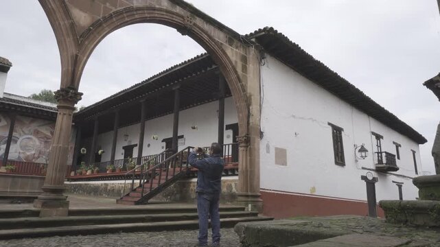 Un visitante turista tomando fotos a la arquitectura de pueblo m&aacute;gico