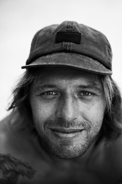 Black an white portrait of a happy young man with freckles.
