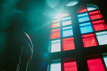 Low angle shot of red and blue colored stained glass windows with sun rays
