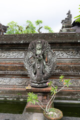 Close Up of Ancient Balinese female Gate Guardian Statue with guitar, sitar or Mandolin - Bedogol or dwarapala, Dvarapala, Dvarapalaka) outside home in Bali, Indonesia