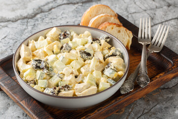 Delicious salad with chicken, prunes, cucumber and eggs close-up in a bowl on the table. Horizontal
