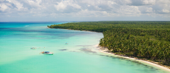 Obraz premium Aerial shot of Saona Island.Caribbean Sea with clear green water.Boats sailed to the island and tourists bathe in natural pools in the middle of the ocean.Dominican republic.