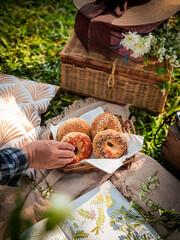 Picnic in garden. Reading books. Breakfast bagels in park. Summer vibes.
