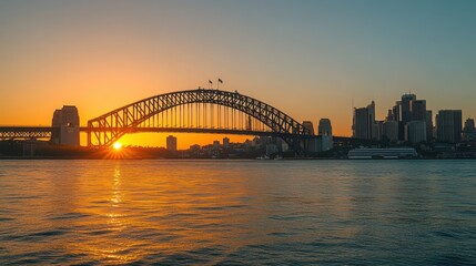 Naklejka premium A sunset view of the Sydney Harbour Bridge with city skyline reflections on the water.