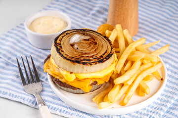 Flying Dutchman Onion Wrapped viral trendy Burger. Homemade cheeseburger with Onion Bun, nuggets and french fries