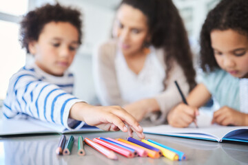 Hand, homework and kids with books, education and teaching in house, studying and learning in kitchen. Home, children and mom with pride for growth, development and knowledge of siblings with pencil