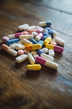Pile of Pills on Wooden Table