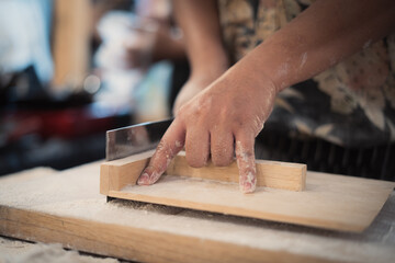 Making fresh soba noodles in a Thai market 