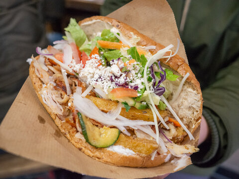 a big kebab sandwich with a lot of meat and vegetables in berlin