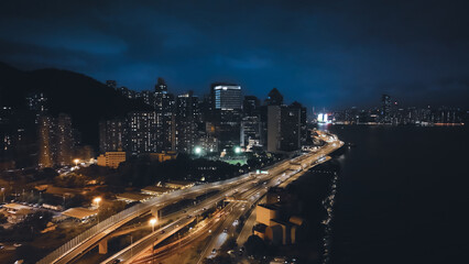 Bright night panorama showcasing the skyline of Hong Kong with vibrant city lights and flowing traffic along the waterfront