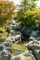 Triple waterfall splits into three streams in Japanese garden. Public landscape park of Krasnodar or Galitsky Park, Russia.