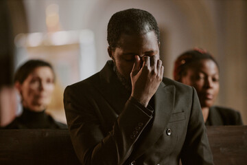 Broken inside African American man dressed in total black cant hold back tears during burial...