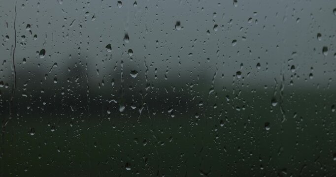 drop of rain on a window. close-up of a window with water drops. drop of rain trickles down the window pane. a window in rainy weather