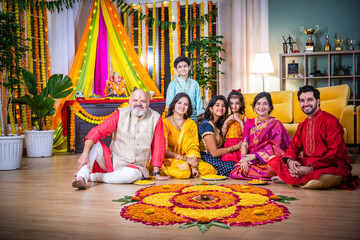 Indian family bonding over creating rangoli during Diwali or Ganesh festival celebration