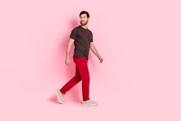 Full length photo of nice man with bristle dressed brown t-shirt red pants walk look at sale empty...