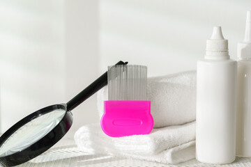 Lice treatment product next to a nit comb and magnifying glass
