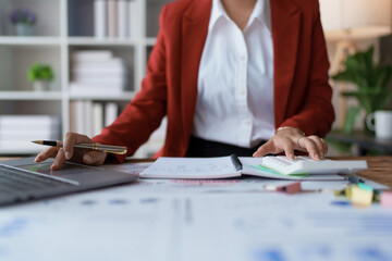 woman meticulously plans a finance audit, using a computer and calculator to review budget...