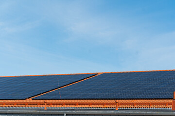 bunch of solar panels on roof during sunny day with blue sky