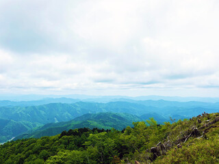 山頂から見る山並みと曇り空