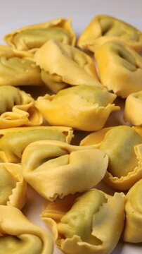 tortellini, rotation in circle. fresh pasta, Turning. Typical Italian dish. ravioli tortellini with parmesan cheese. vertical video 