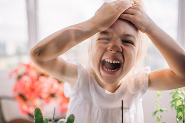charming child fooling around with his face pressed against the glass