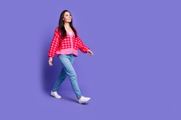 Full length photo of shiny attractive lady dressed pink cardigan walking empty space isolated violet color background