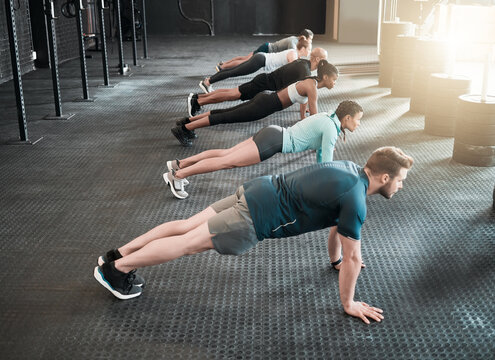 Group, push up and health training for fitness, exercise and gym class, club or core workout for challenge. People, personal trainer or friends collaboration for weight loss, endurance and cardio