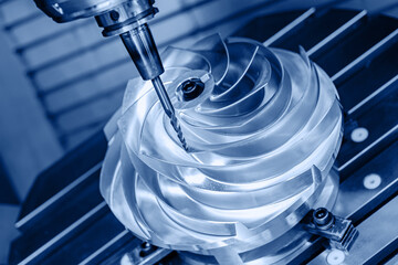 Five axis CNC machining center cutting engine turbine, blue toning. Concept modern technology for...