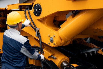 Machinery tractor mechanic checks hydraulic hose system equipment on excavator © Parilov